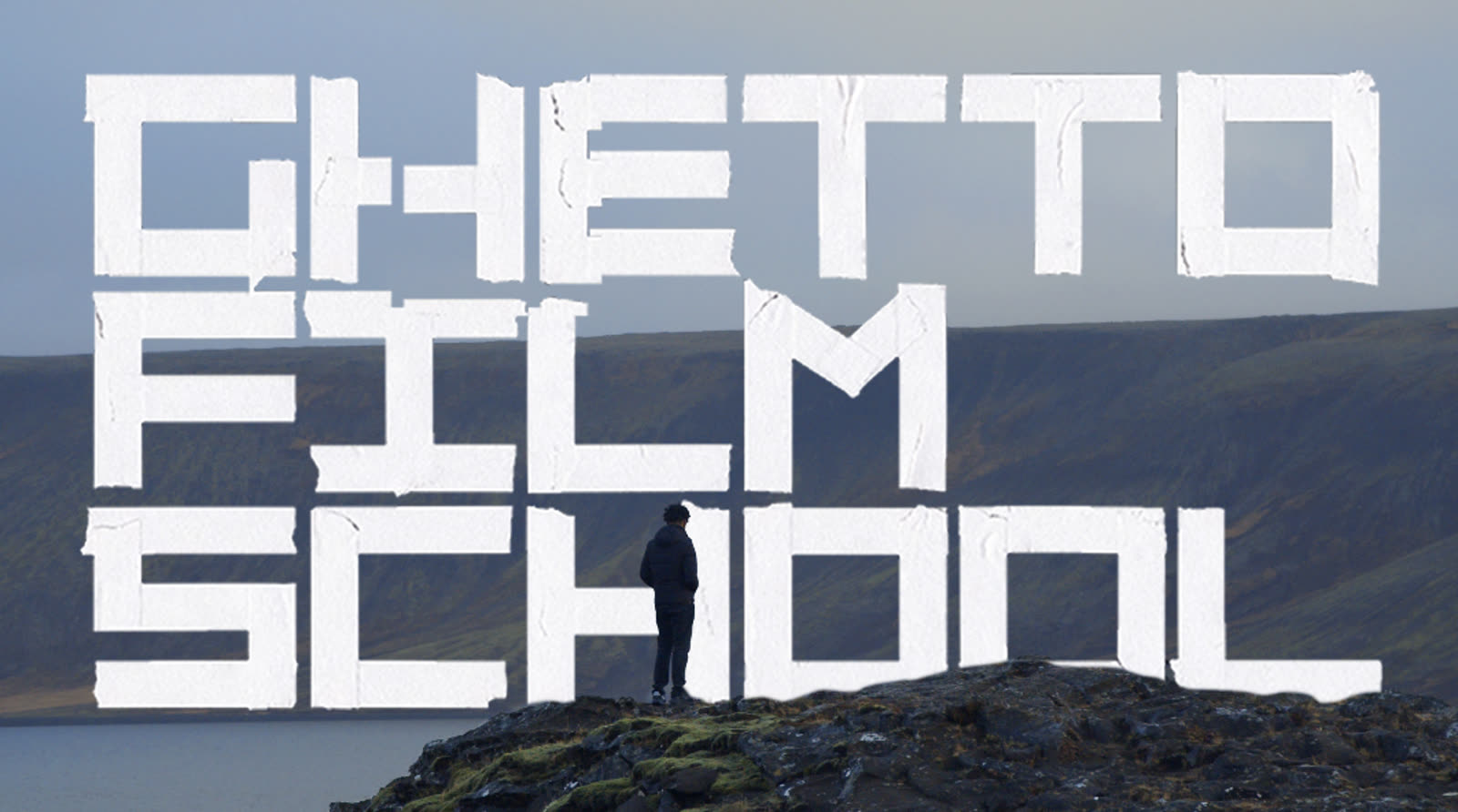 Ghetto Film School title card over a lone figure standing on a rocky outcrop above water.