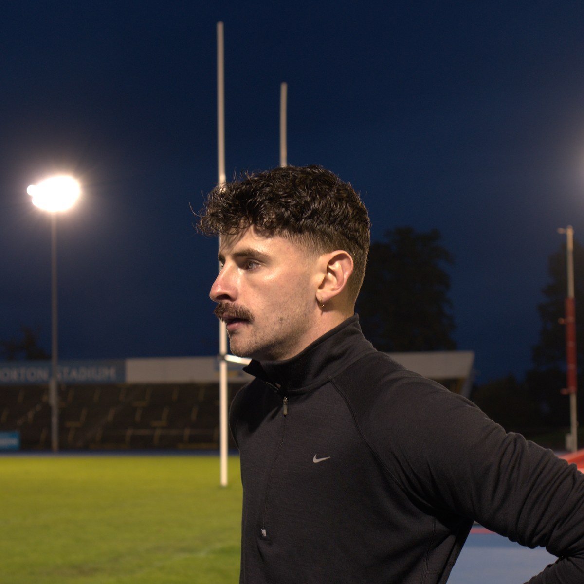 The runner waiting out a reset under the floodlights.